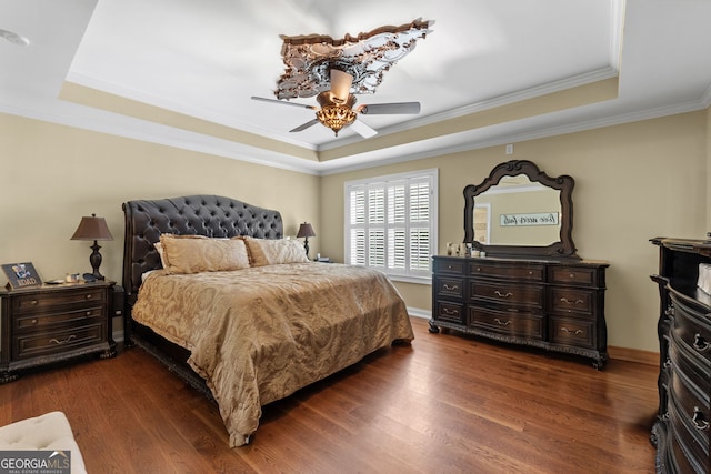 bedroom with dark wood-type flooring, ceiling fan, and a raised ceiling