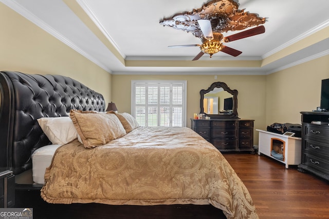 bedroom with ceiling fan, dark hardwood / wood-style flooring, ornamental molding, and a raised ceiling