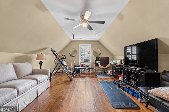 exercise room with ceiling fan, hardwood / wood-style floors, and lofted ceiling