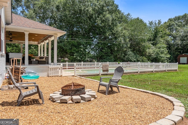 view of yard with ceiling fan, a patio area, and a fire pit