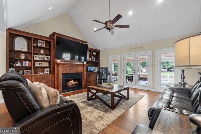 living room with ceiling fan, high vaulted ceiling, french doors, and light wood-type flooring