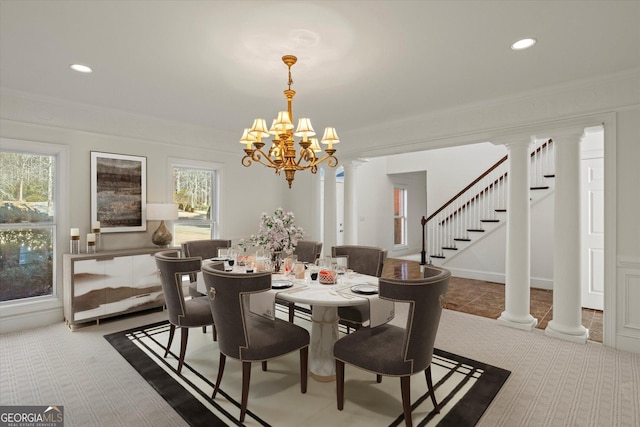 dining space with a healthy amount of sunlight, crown molding, and a notable chandelier