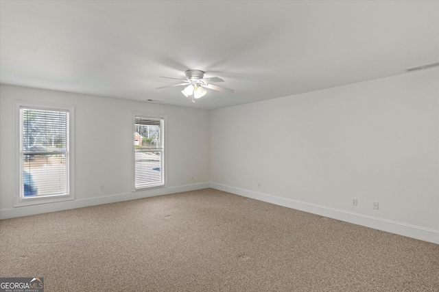 empty room with carpet flooring, a wealth of natural light, and ceiling fan