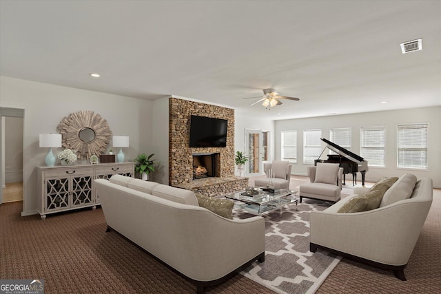 carpeted living room with a fireplace and ceiling fan