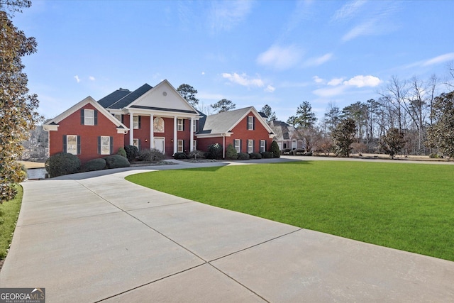 greek revival inspired property featuring a front lawn