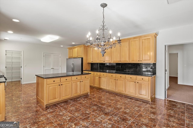 kitchen featuring stainless steel fridge, light brown cabinets, an inviting chandelier, and a kitchen island