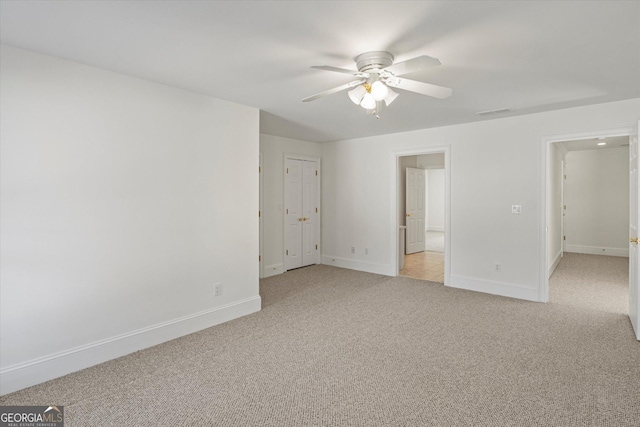 interior space with ceiling fan and light colored carpet