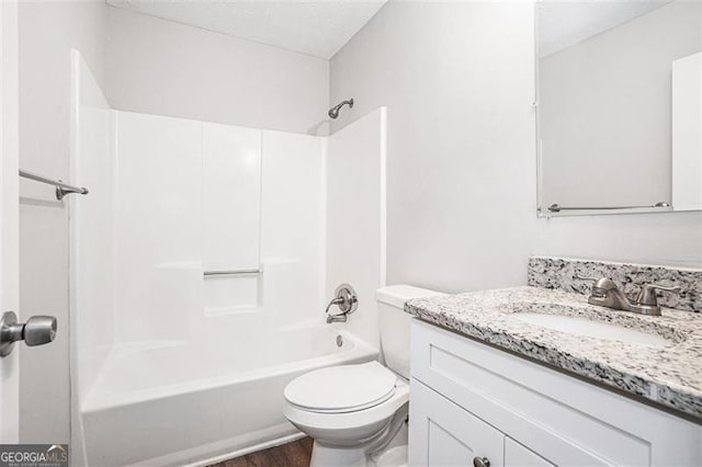 full bathroom with washtub / shower combination, vanity, hardwood / wood-style flooring, and toilet