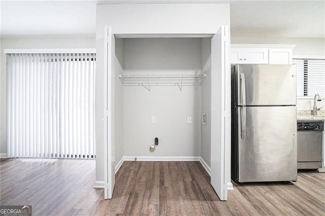 laundry room with hardwood / wood-style flooring and sink