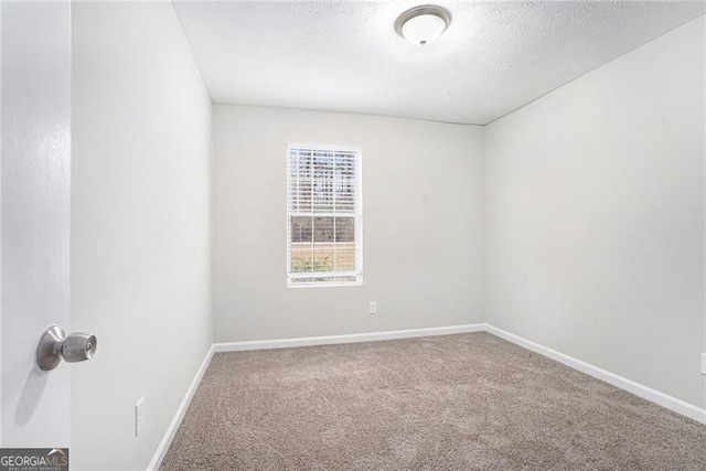 carpeted empty room featuring a textured ceiling