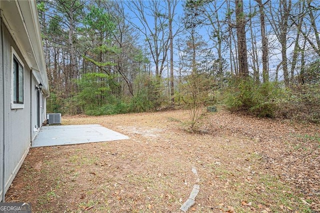 view of yard with cooling unit and a patio