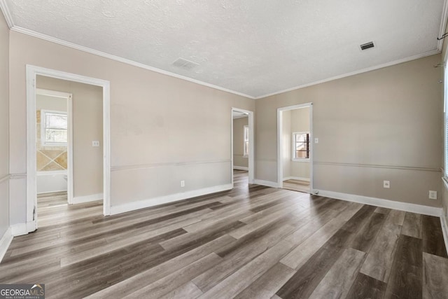 unfurnished room featuring a textured ceiling, ornamental molding, and dark wood-type flooring