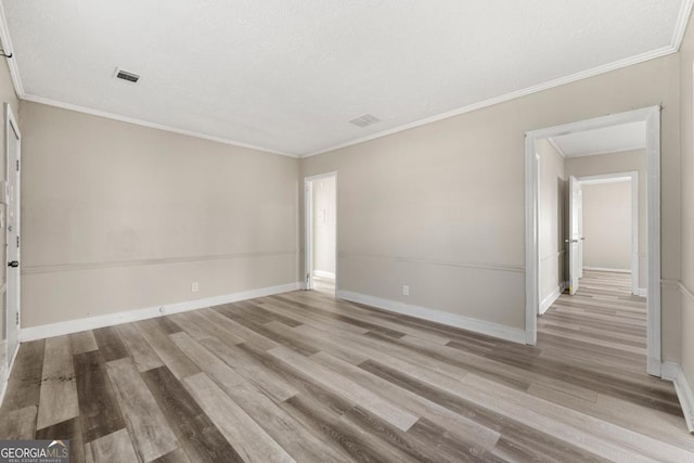 spare room featuring light hardwood / wood-style floors and ornamental molding