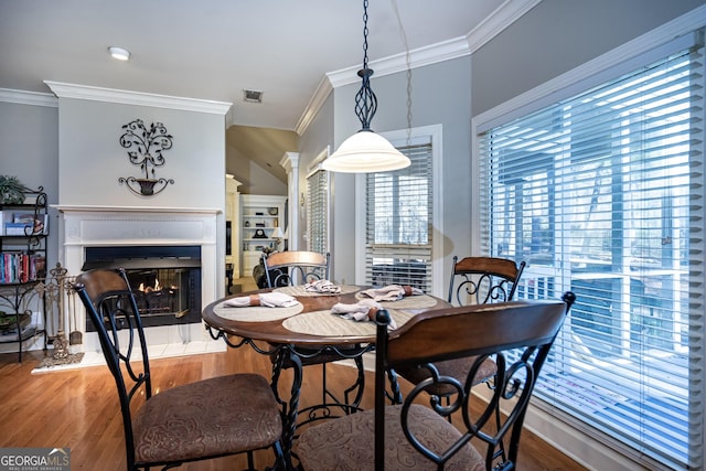 dining area with wood-type flooring and ornamental molding