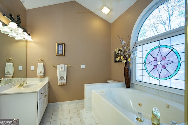 bathroom featuring tile patterned flooring, vanity, vaulted ceiling, and a washtub