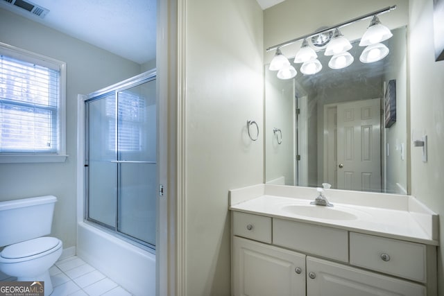 full bathroom with tile patterned floors, vanity, bath / shower combo with glass door, and toilet