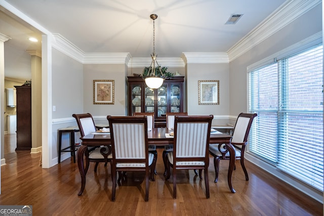 dining room with crown molding and dark hardwood / wood-style flooring