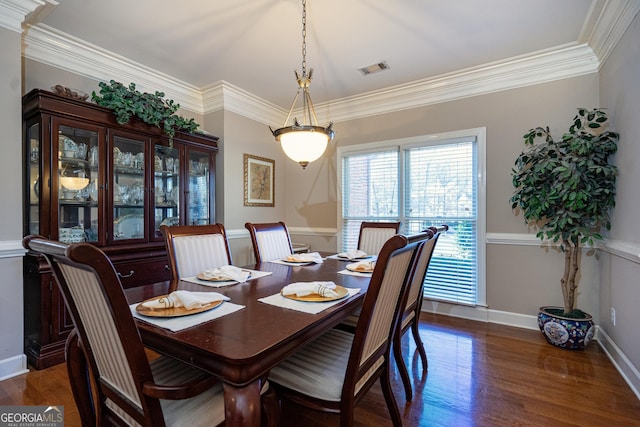 dining space with crown molding and dark wood-type flooring