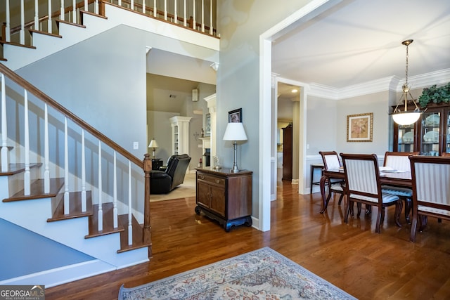 foyer entrance with crown molding and dark hardwood / wood-style floors