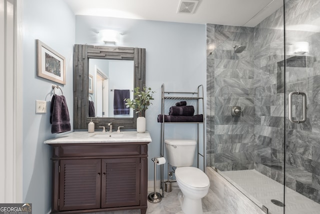 bathroom with vanity, toilet, and a shower with door