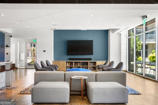 living room featuring wood-type flooring and a wall of windows