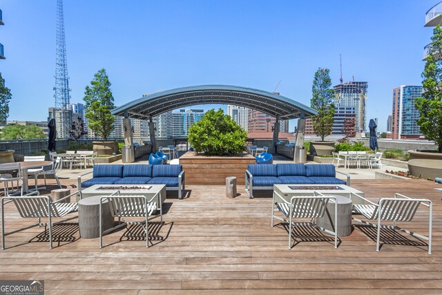 deck featuring an outdoor living space with a fire pit