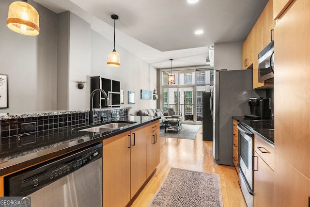 kitchen with hanging light fixtures, light brown cabinetry, sink, and appliances with stainless steel finishes