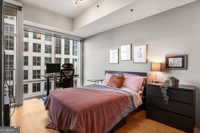 bedroom featuring light hardwood / wood-style floors and a wall of windows