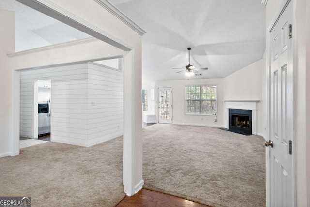 unfurnished living room with ceiling fan, carpet, and vaulted ceiling