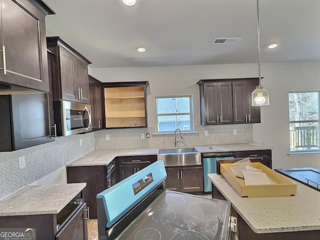 kitchen featuring decorative light fixtures, sink, decorative backsplash, and stainless steel appliances