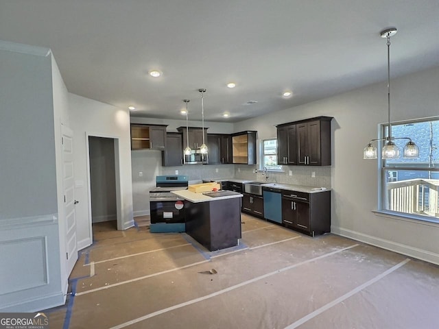 kitchen featuring pendant lighting, sink, appliances with stainless steel finishes, dark brown cabinets, and a kitchen island