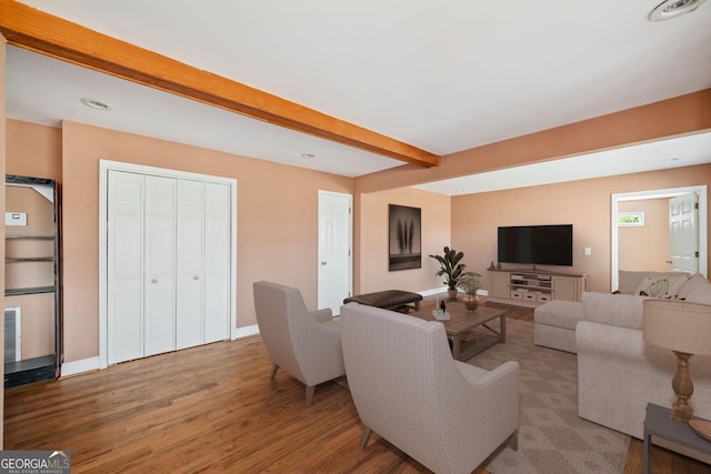 living room featuring beamed ceiling and wood-type flooring