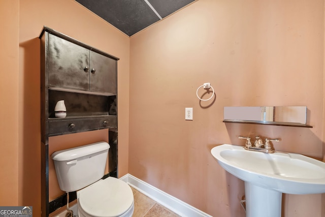 bathroom with tile patterned flooring, lofted ceiling, sink, and toilet