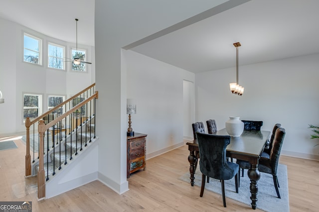 240 Good Hope Preserve, Good Hope, GA 30641 - dining space with light wood-style flooring, stairway, a ceiling fan, a high ceiling, and a chandelier