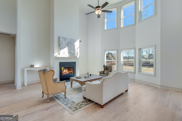 240 Good Hope Preserve, Good Hope, GA 30641 - living area featuring a towering ceiling, a warm lit fireplace, wood finished floors, and a ceiling fan