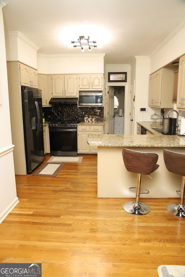 kitchen with kitchen peninsula, decorative backsplash, light hardwood / wood-style flooring, and appliances with stainless steel finishes