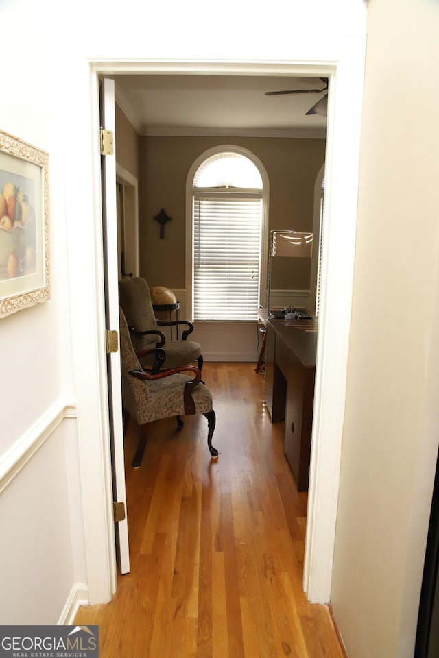 hall featuring light wood-type flooring and ornamental molding