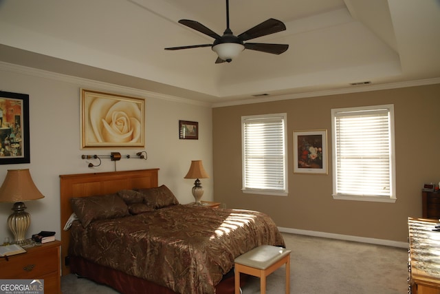 bedroom with a tray ceiling, ceiling fan, crown molding, and carpet floors