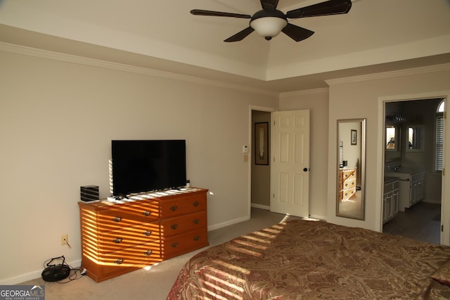 carpeted bedroom featuring ceiling fan, a raised ceiling, crown molding, and connected bathroom