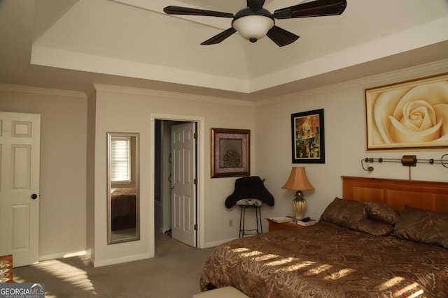 carpeted bedroom with a raised ceiling, ceiling fan, and ornamental molding