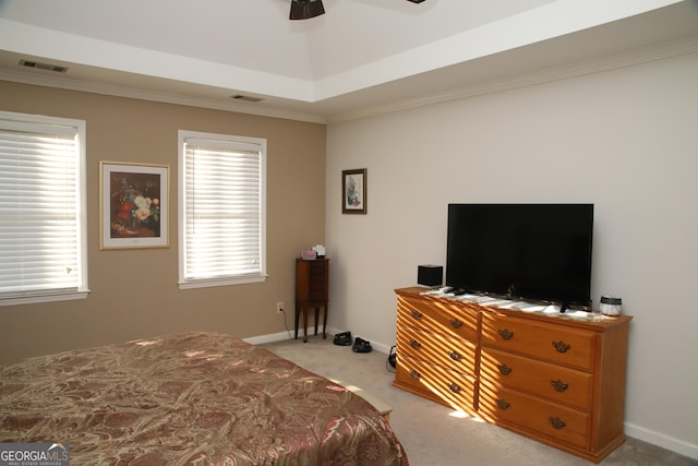 carpeted bedroom with a raised ceiling, ceiling fan, and ornamental molding