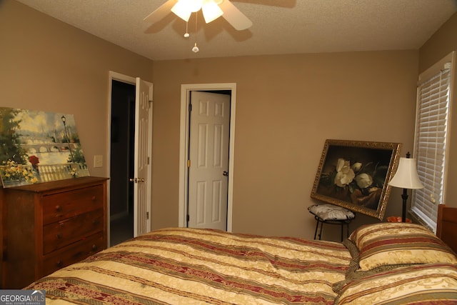 bedroom featuring ceiling fan and a textured ceiling