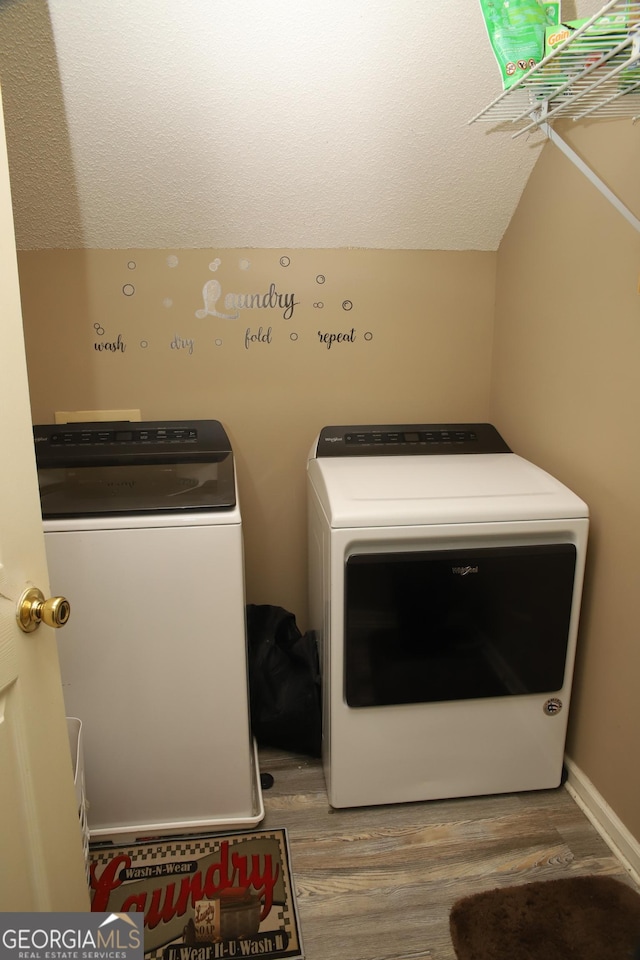 laundry room with hardwood / wood-style floors, a textured ceiling, and washer and clothes dryer