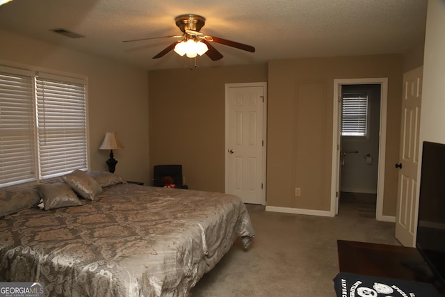 bedroom featuring a textured ceiling, ceiling fan, and light carpet