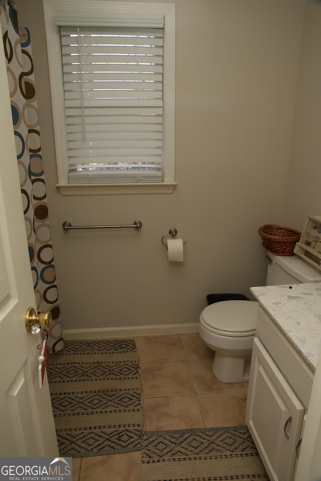 bathroom featuring tile patterned flooring, vanity, and toilet