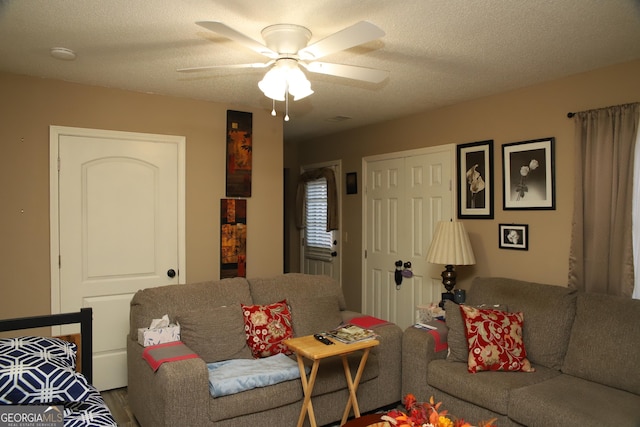 living room featuring a textured ceiling and ceiling fan