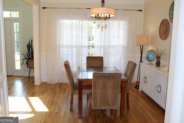 dining space featuring an inviting chandelier, a wealth of natural light, and light hardwood / wood-style flooring