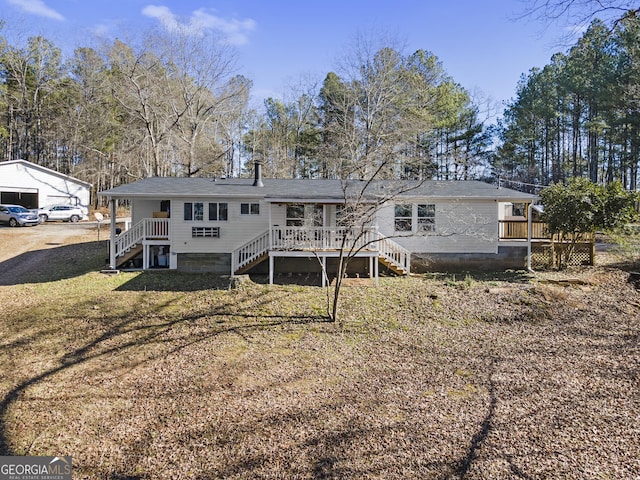 rear view of property with a lawn and a deck