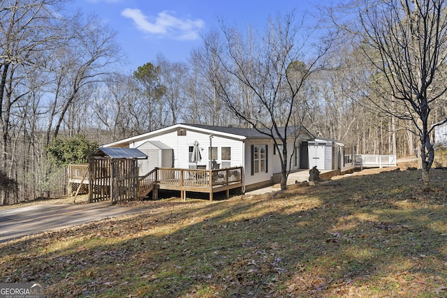 back of house featuring a lawn and a wooden deck