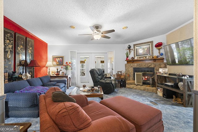 living room with carpet, french doors, a textured ceiling, ceiling fan, and a fireplace